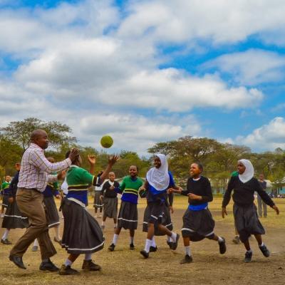 Projects Abroad volunteers coach sports with students in schools in Tanzania. Volunteers coaching sports in schools in Tanzania play a ball game with students.